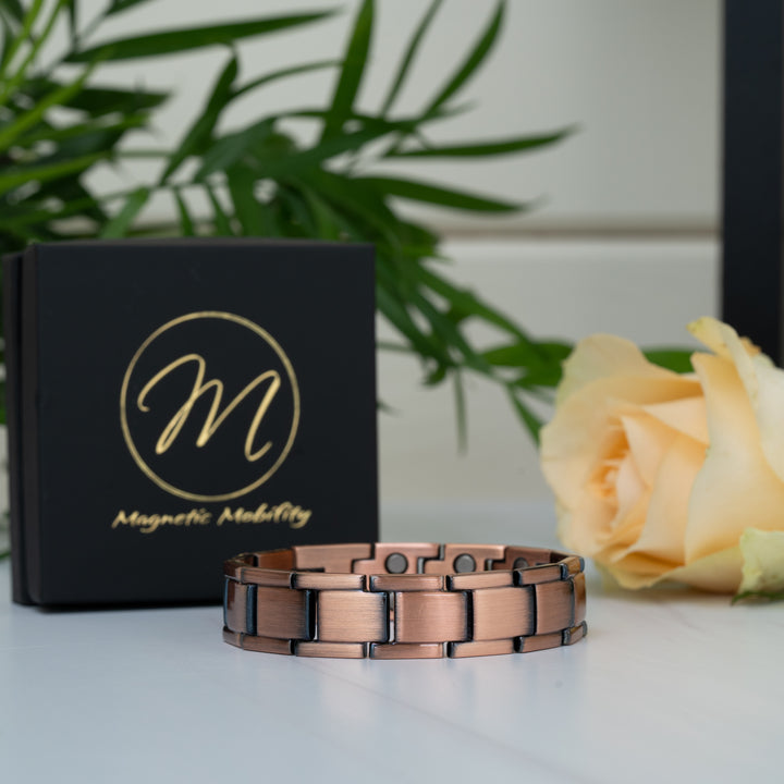 Alexander's Copper Double Strength Magnetic Bracelet displayed with a rose and Magnetic Mobility gift box, highlighting its elegant copper links