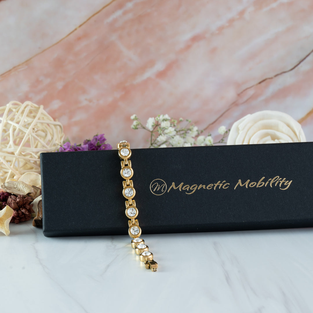 Angelica’s Sun 4in1 Magnetic Bracelet draped over a Magnetic Mobility gift box with flowers