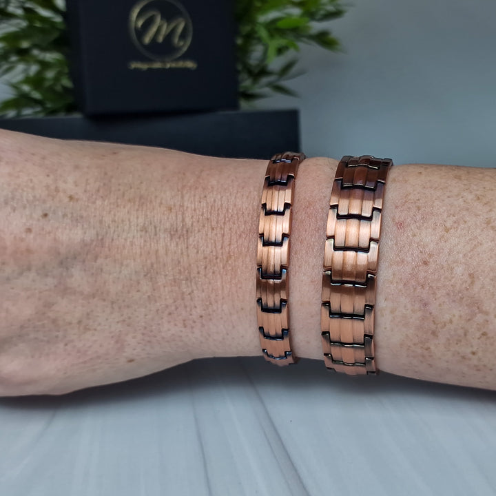 Ashe Copper Magnetic Bracelets - Slim 9mm and Wide 15mm styles - worn together on a wrist, showcasing their contrasting yet complementary sizes and elegant copper design.