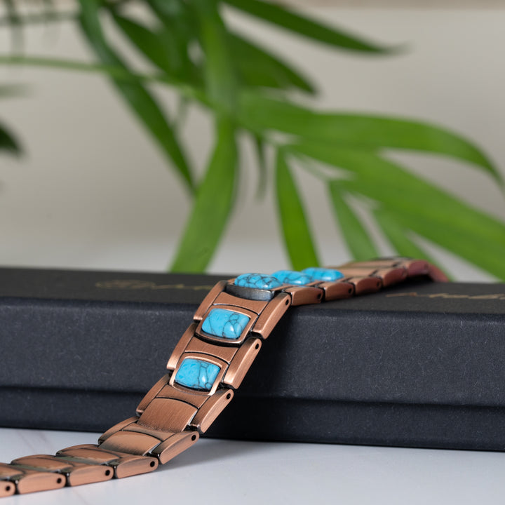 Asphodel Copper Magnetic Bracelet lying on top of a sleek black gift box, emphasising the intricate design and high-quality finish of the copper and turquoise stones.