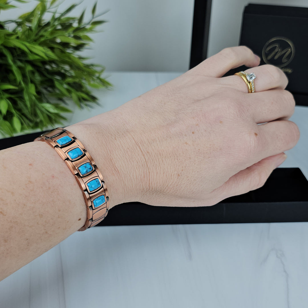 Asphodel Copper Magnetic Bracelet worn on a wrist, showcasing its stylish design and comfortable fit, complemented by oval turquoise stones.
