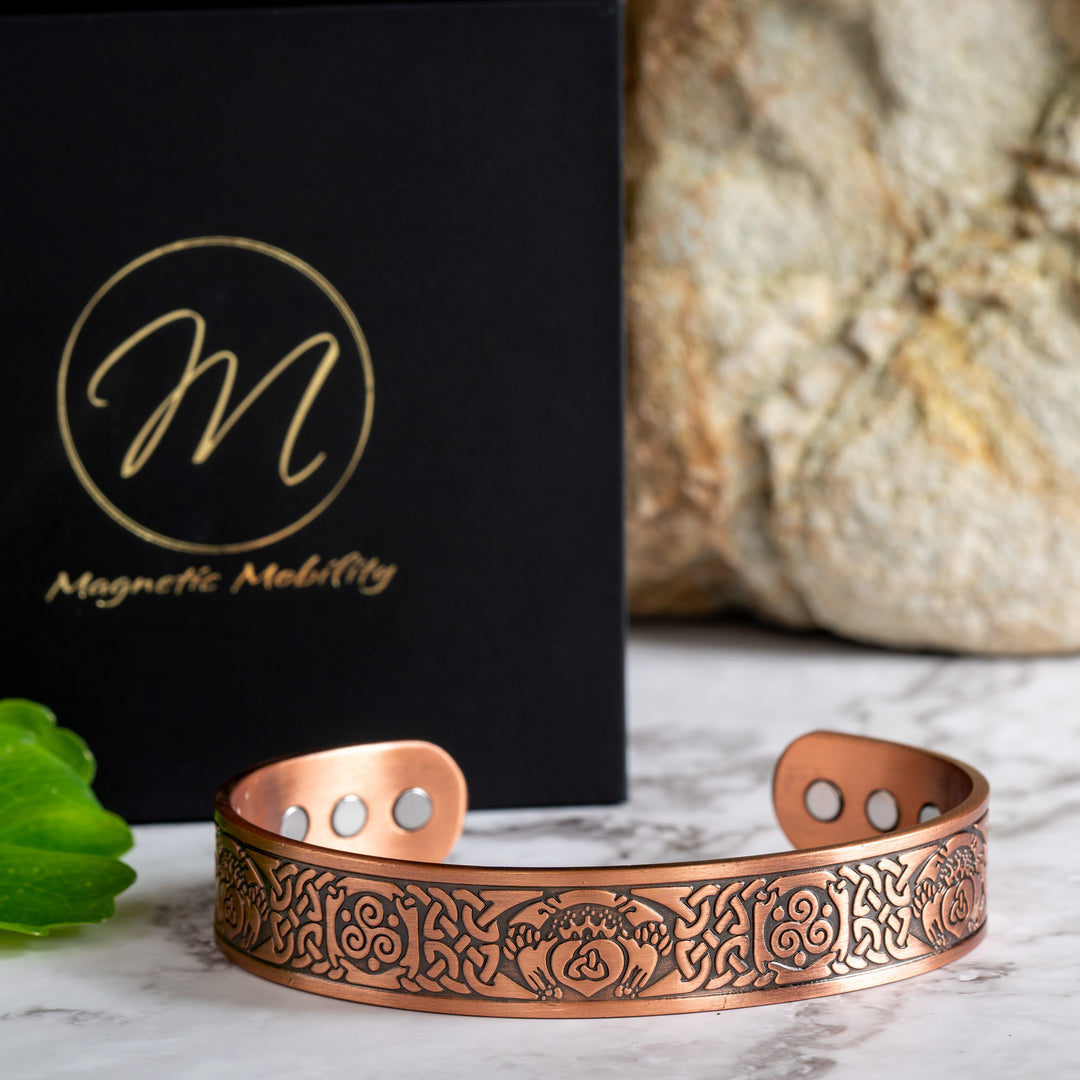 Claddagh copper bracelet featuring a claddagh design - A crowned heart held by two hands - Symbolically, the heart represents love, the crown denotes loyalty, and the hands are a sign of friendship. Inside the heart is a  triquetra symbol. The Claddagh design is surrounded by Celtic designs.