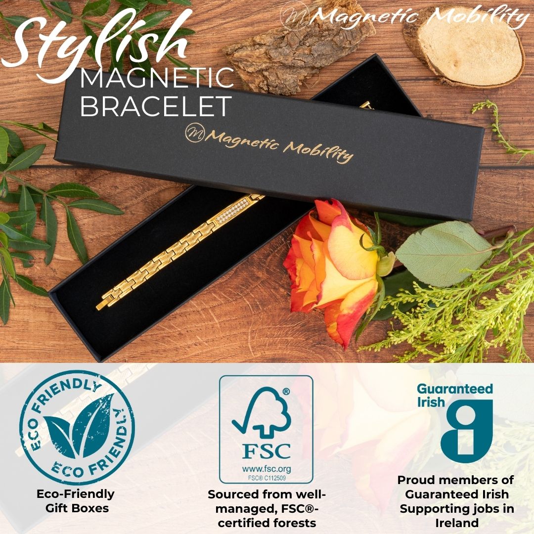Gold 4in1 Magnetic Bracelet from Magentic Mobility with a centerpiece, adorned with two rows of shimmering Swarovski crystals. Shown in a Black Magnetic Mobility Gift box with a rose beside it. Logos depicting the Eco-friendly nature of the packaging and the FSC paper. Also showing the Guaranteed irish logo