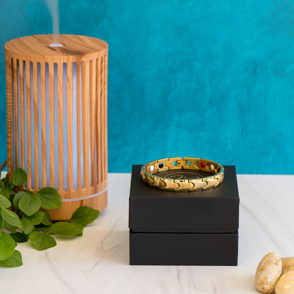 Front view of the gold-plated Rowan Sun Men's 4in1 Magnetic Bracelet, elegantly displayed on a box. The bracelet's interconnected design with matte inlay and shiny edge stripe is clearly visible. A perfect blend of style and wellness, featuring elements like Neodymium magnets, Germanium, Negative ions, and Far Infrared (FIR) components.