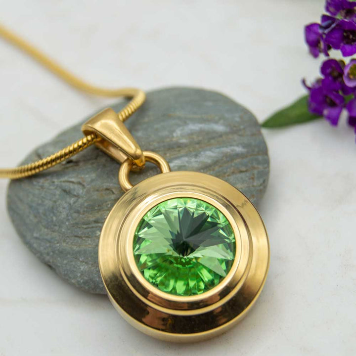 Front view of the Angelica sun gold plated magnetic necklace with a green Swarovski stone . The necklace is perfect for people with arthritis.