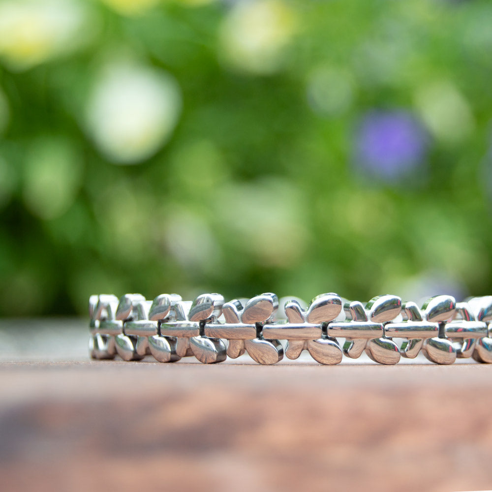 Buddleia Moon - Silver Coloured Women's Magnetic Health Bracelet with butterfly desings. Bracelet pictured in front of white Luxury gift box with flowers