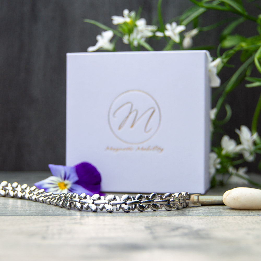 Buddleia Moon - Silver Coloured Magnetic Bracelet  front view - image shows the bracelet in front of Green plants