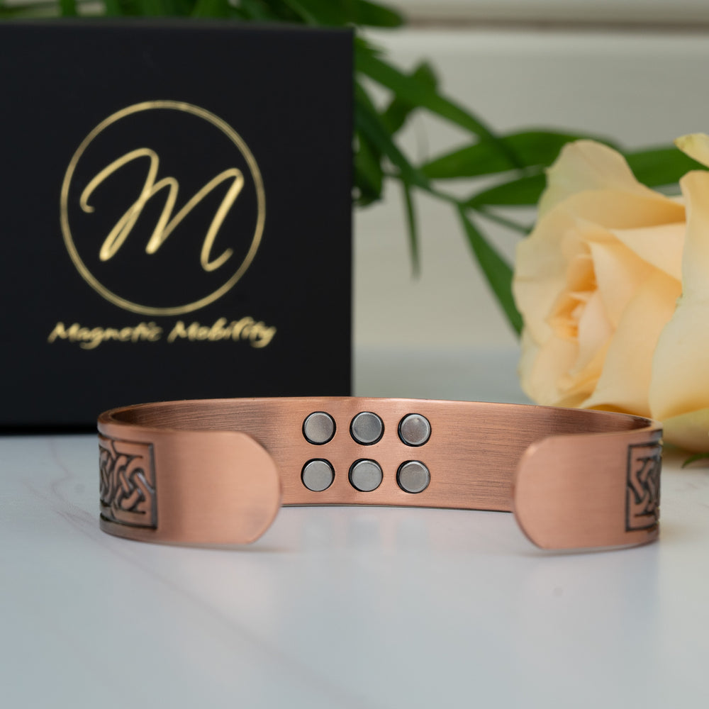 Back view of the Burdock Copper Bracelet with the open bangle showing six magnets and adjustable ends for a custom fit.