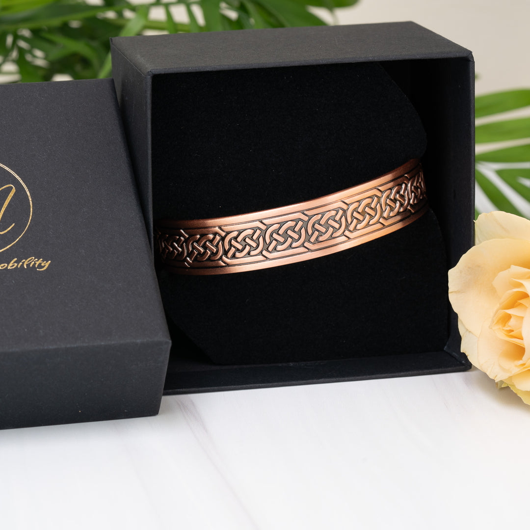  Another view of the Burdock Copper Bracelet in the gift box, showcasing the engraved Celtic knot design and copper sheen, ideal for gifting.