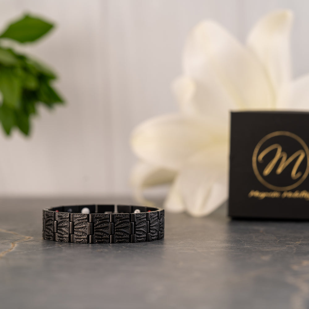 Side view of the Burnet Night 4in1 Magnetic Bracelet with detailed engraving on the black stainless steel links, presented next to a Magnetic Mobility box.