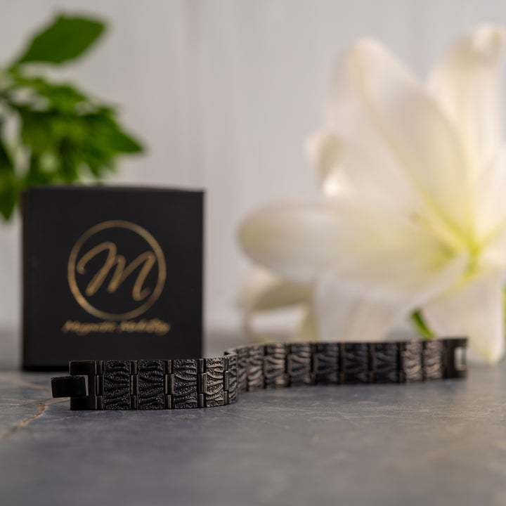 legant all-black Burnet Night Magnetic Bracelet laid out straight, showing the detailed texture and elements for wellness benefits.