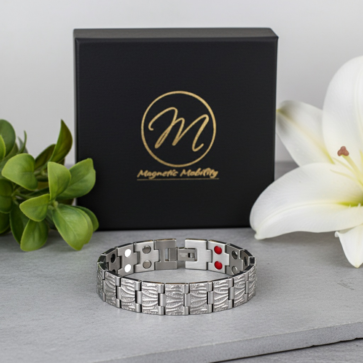 Silvermagnetic bracelet with rdouble elements on a gray surface next to a black box with 'Magnetic Mobility' branding.