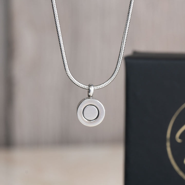 December birthstone magnetic necklace with a snake chain, featuring a minimalist back view of the pendant with a magnetic clasp, displayed against a black background with Magnetic Mobility branding