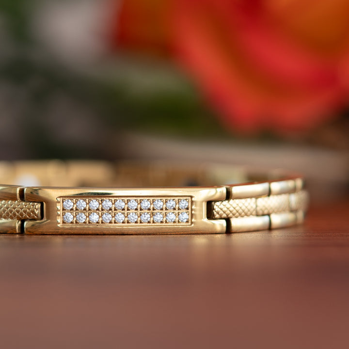 Gold 4in1 Magnetic Bracelet from Magentic Mobility with a centerpiece, adorned with two rows of shimmering Swarovski crystals. Close up view