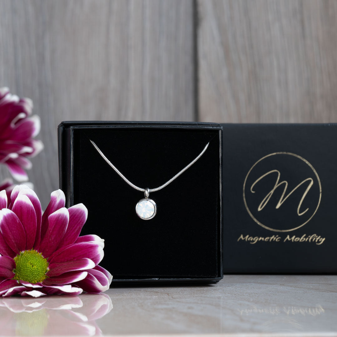 Elegant June Birthstone magnetic necklace with a Swarovski Pearl pendant, showcased in a sleek black box with a reflective surface. The necklace embodies timeless beauty, perfect for celebrating June birthdays with style and wellness.