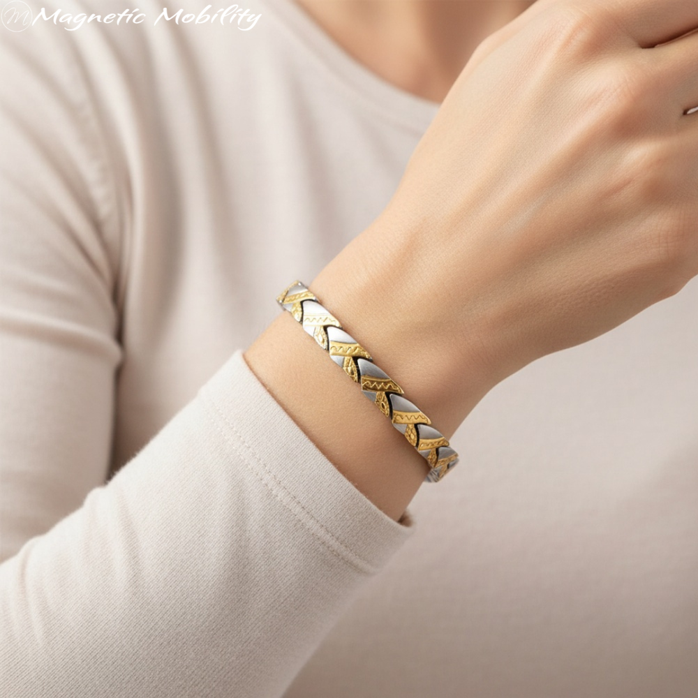 Gold and silver magnetic bracelet on a wrist with a neutral background