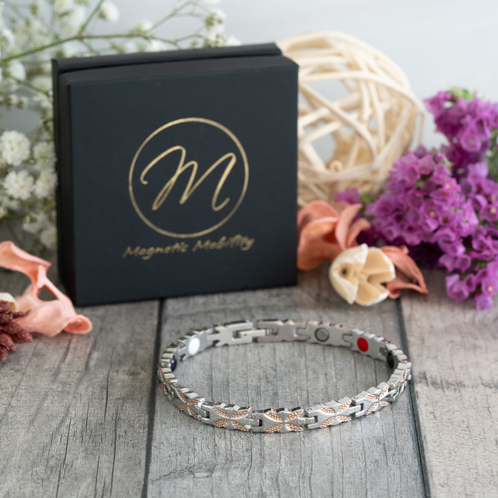 Meadowsweet Dusk 4in1 Magnetic Bracelet displayed at a 45-degree angle, showing its silver and rose gold butterfly design, perfect for arthritis relief and joint pain.