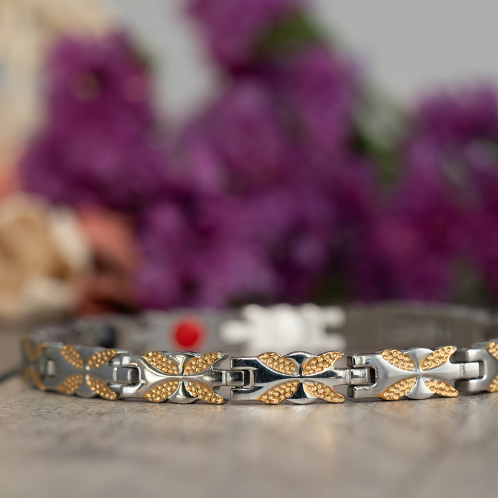 Close-up of the intricate butterfly design on the Meadowsweet Moon 4in1 Magnetic Bracelet in silver and gold. A fashionable accessory infused with Neodymium magnets, FIR elements, Germanium, and Negative Ions to alleviate arthritis and joint discomfort.