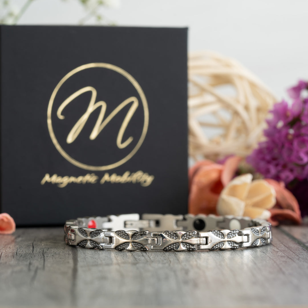 Front view of the Meadowsweet Night 4in1 Magnetic Bracelet by Magnetic Mobility, featuring a silver and black butterfly design with health elements for arthritis relief.