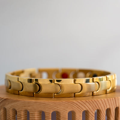Close-up view of the gold-plated Rowan Sun Men's 4in1 Magnetic Bracelet, highlighting the intricate details of its interconnected design with a matte inlay and shiny edge stripe. Emphasizes the bracelet's unique blend of style and wellness, showcasing embedded elements like Neodymium magnets, Germanium, Negative ions, and Far Infrared (FIR) components