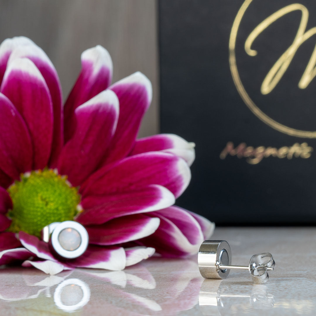 Close-up view of the June Birthstone magnetic earrings featuring a Swarovski Pearl, displayed elegantly with a pink and white flower backdrop. The earrings showcase a timeless design, ideal for celebrating June birthdays.