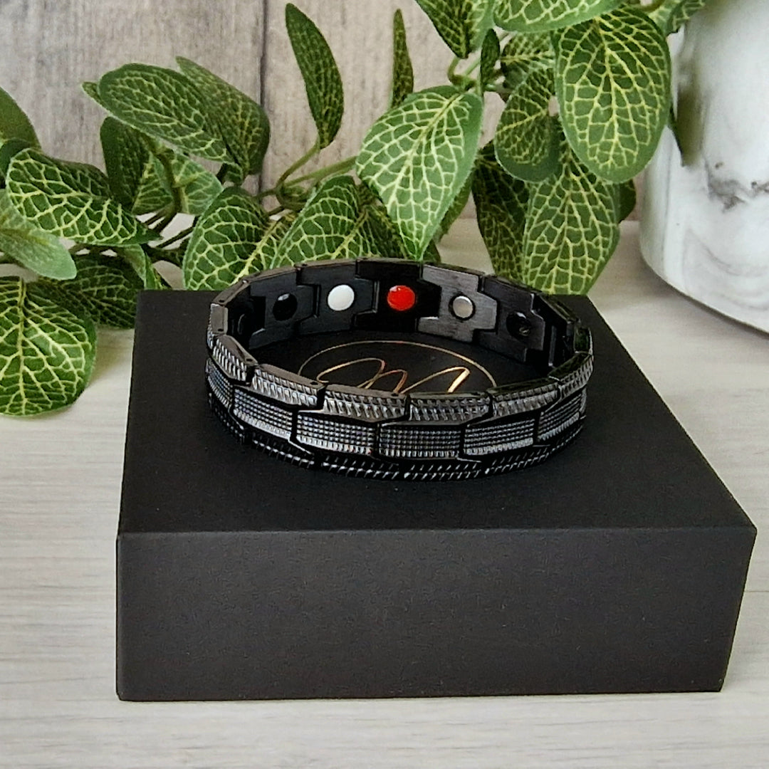 Angled view of Gentian Night Magnetic Bracelet showcasing its all-black tire-tread design and 4in1 elements for supporting arthritis and joint health.