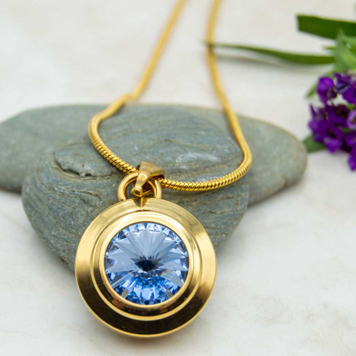 Front view of the Angelica Sun gold plated magentic necklace with a blue Swarovski stone . The Necklace is perfect for people with arthritis or pain. 