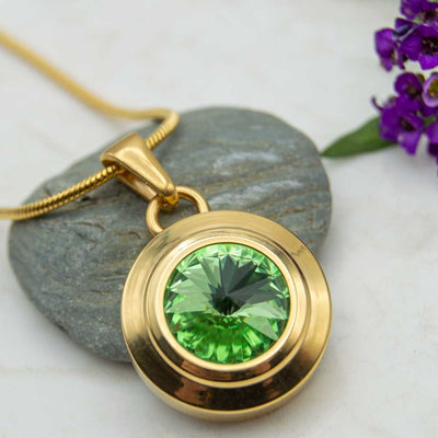 Front view of the Angelica sun gold plated magnetic necklace with a green Swarovski stone . The necklace is perfect for people with arthritis. 
