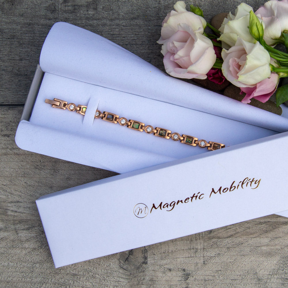 Top view of the rose gold magnetic bracelet in a white gift box with roses, 