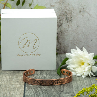 Thin style Buckthorn Copper Bracelet with the symbolic Tree of Life design set against a white eco-friendly gift box, a stylish aid for arthritis relief.