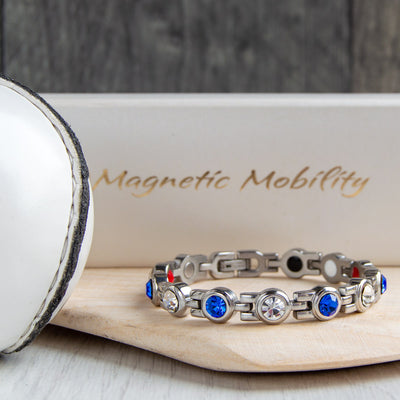 Cavan County GAA Inspired Women's Magnetic Bracelet showcased on a hurl. A symbol of county pride and magnetic therapy relief for migraines, sports injuries, and fibromyalgia.