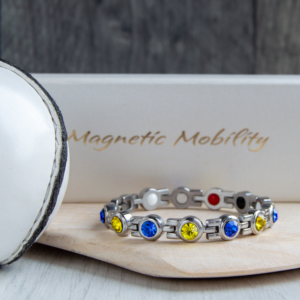 Clare County GAA Inspired Women's Magnetic Bracelet on a hurl. This accessory combines county colours with magnetic therapy benefits, aiding in relief from migraines, sports injuries, and more
