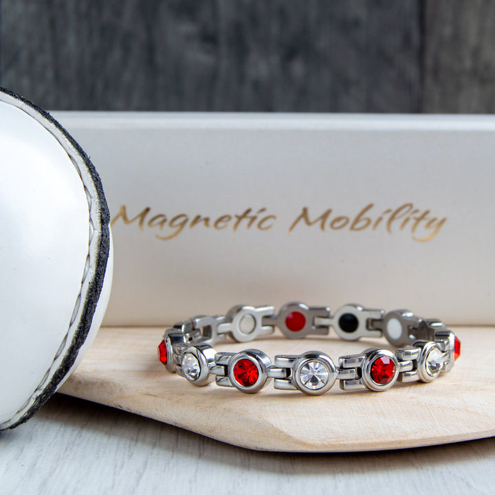 Cork County GAA Inspired Women's Magnetic Bracelet displayed on a hurl. Embodying county pride and the benefits of magnetic therapy for conditions such as migraines, sports injuries, and fibromyalgia."  "Cork County GAA Inspired Wom