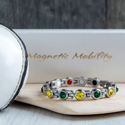 Donegal County GAA Inspired Women's Magnetic Bracelet placed on a hurl. A stylish representation of county pride and the relief provided by magnetic therapy for migraines, sports injuries, and fibromyalgia