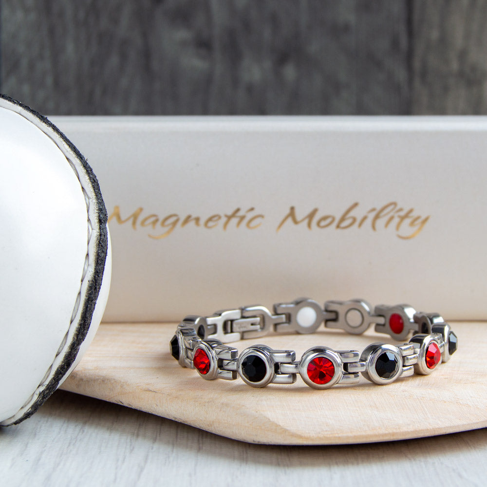 Down County GAA Inspired Women's Magnetic Bracelet on a hurl. Combines county colours with magnetic therapy benefits, providing relief from migraines, sports injuries, and fibromyalgia.