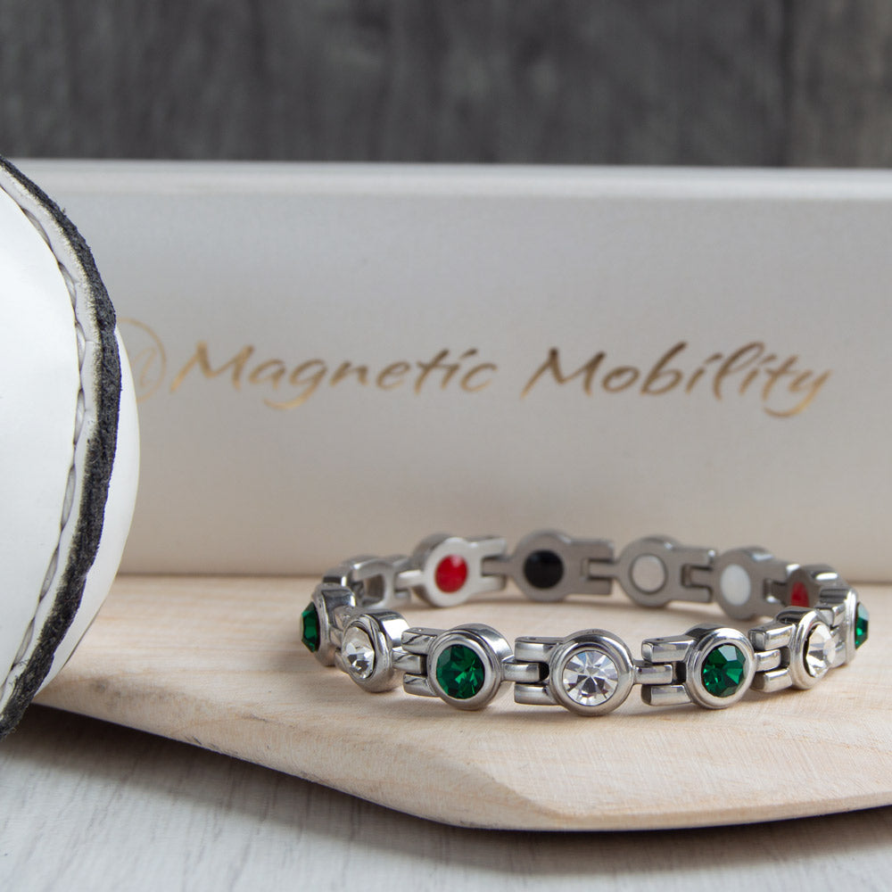 Fermanagh County GAA Inspired Women's Magnetic Bracelet shown on a hurl. A vibrant representation of county pride, providing magnetic therapy benefits for relief from migraines, sports injuries, and fibromyalgia