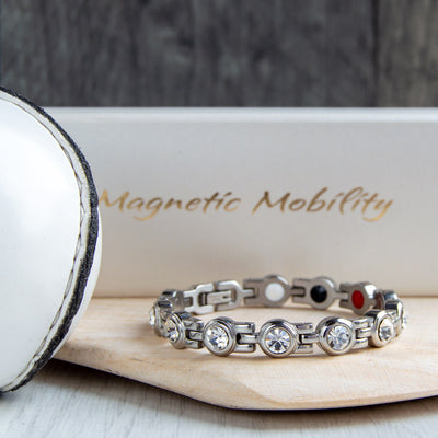 Kildare County GAA Inspired Women's Magnetic Bracelet on a hurl. A stylish accessory that embodies county pride and offers magnetic therapy benefits for migraines, sports injuries, and fibromyalgia.