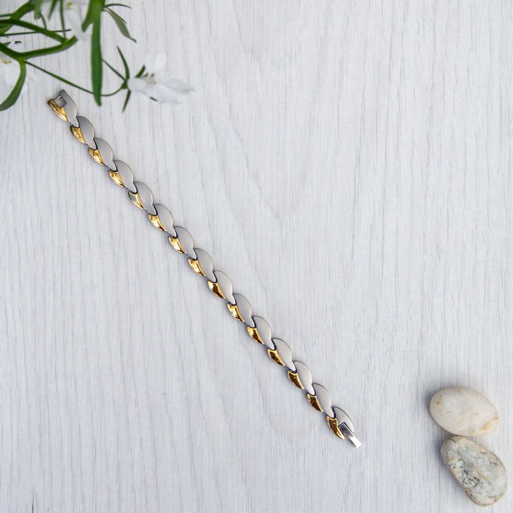 Lobelia Twilight Silver and Gold Women's Magnetic Bracelet - Top View with Lobelia plant and beach pebbles