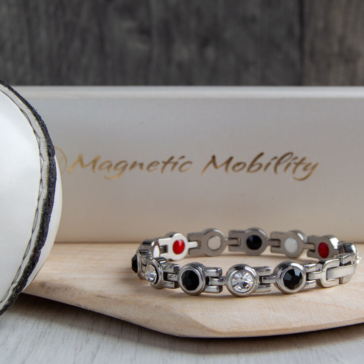 Sligo County GAA Inspired Women's Magnetic Bracelet displayed on a hurl. An embodiment of county pride, offering magnetic therapy benefits for conditions like migraines, sports injuries, and more