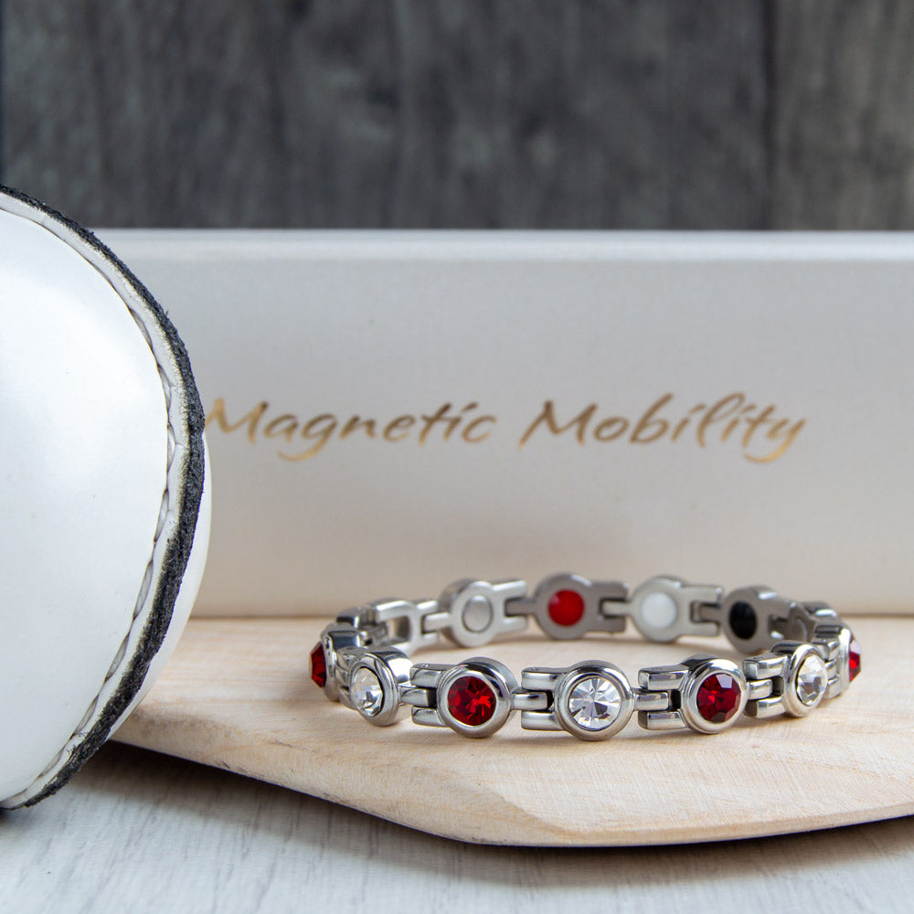 Westmeath County GAA Inspired Women's Magnetic Bracelet on a hurl. Combining county colours and magnetic therapy benefits, providing relief from migraines, sports injuries, and fibromyalgia