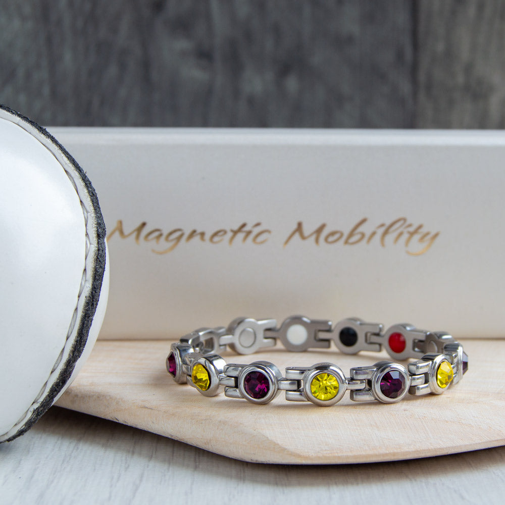 Wexford County GAA Inspired Women's Magnetic Bracelet showcased on a hurl. A stylish blend of county pride and magnetic therapy benefits, aiding in relief from migraines, sports injuries, and more